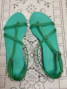 teal Crocs sandals featuring strappy translucent jelly material